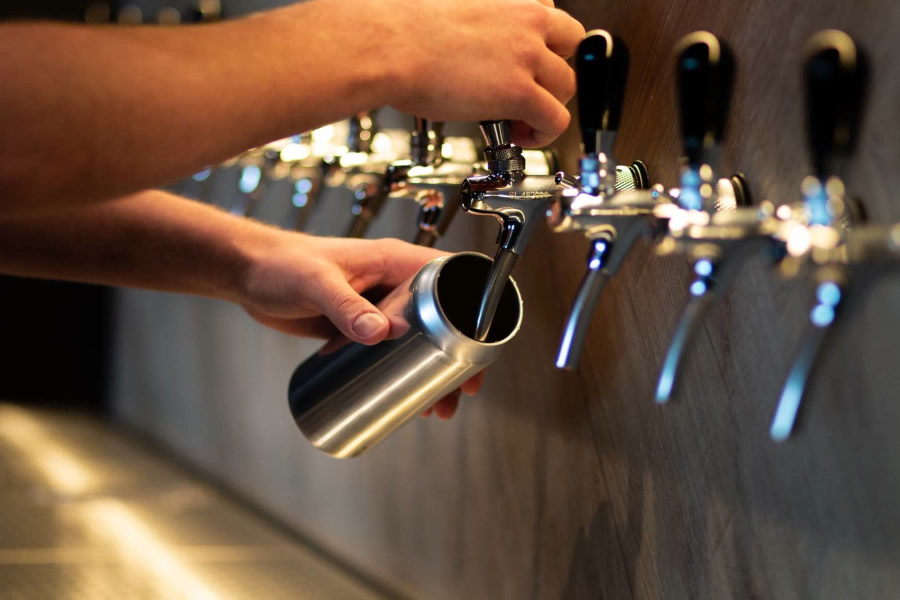 A crowler being filled at the tap wall