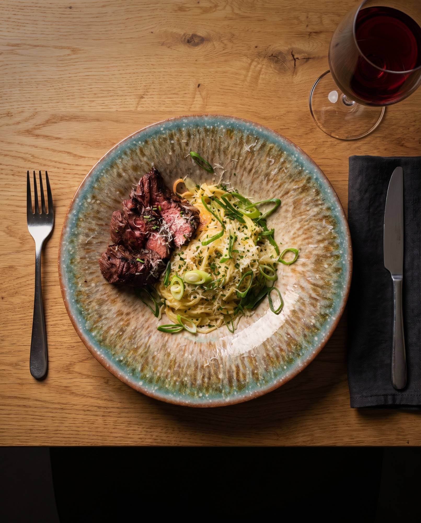 Creamy pasta met gesneden bavette en lente-ui, van bovenaf