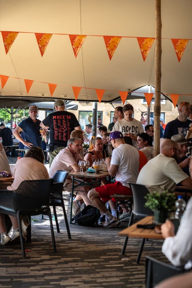 Visitors under the tent with orange bunting at Taphorst '26