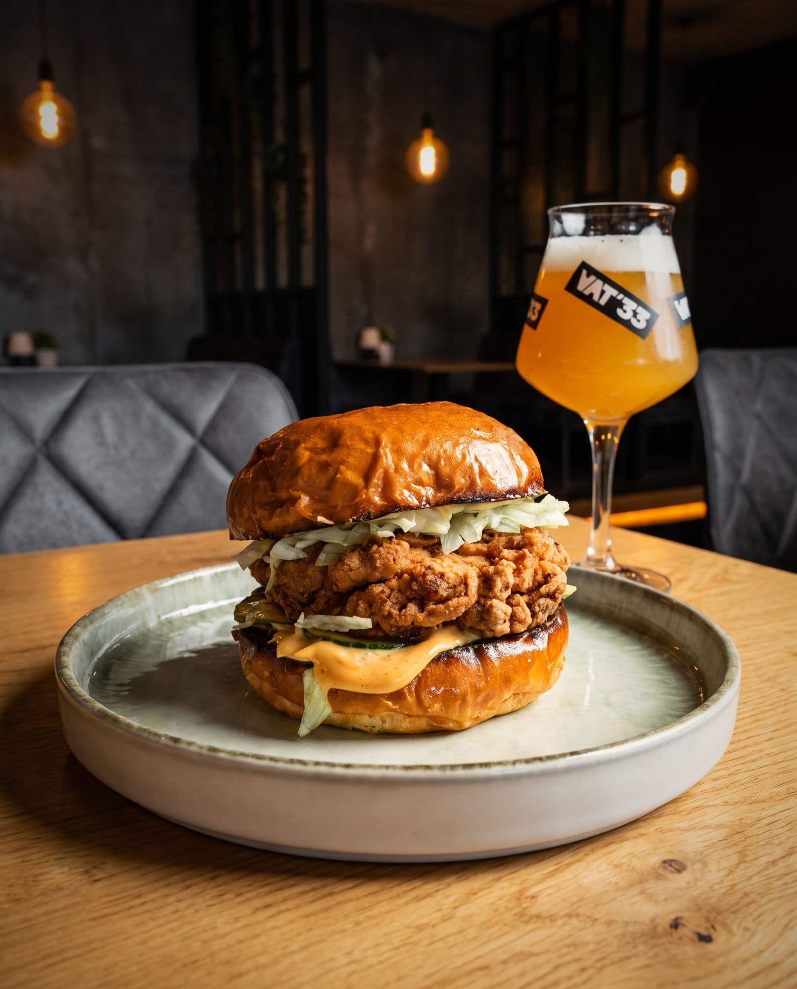 Fried chicken burger met ijsbergsla, augurk en smash saus